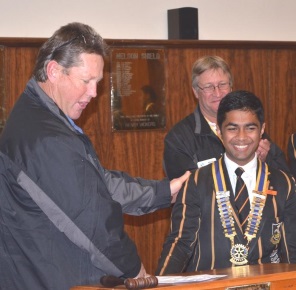 From left, Marc Bradley of the Queenstown Rotary Club inducts Queen's College Interact president Kiran Jomon into the position while Keith Wood applauds at the back